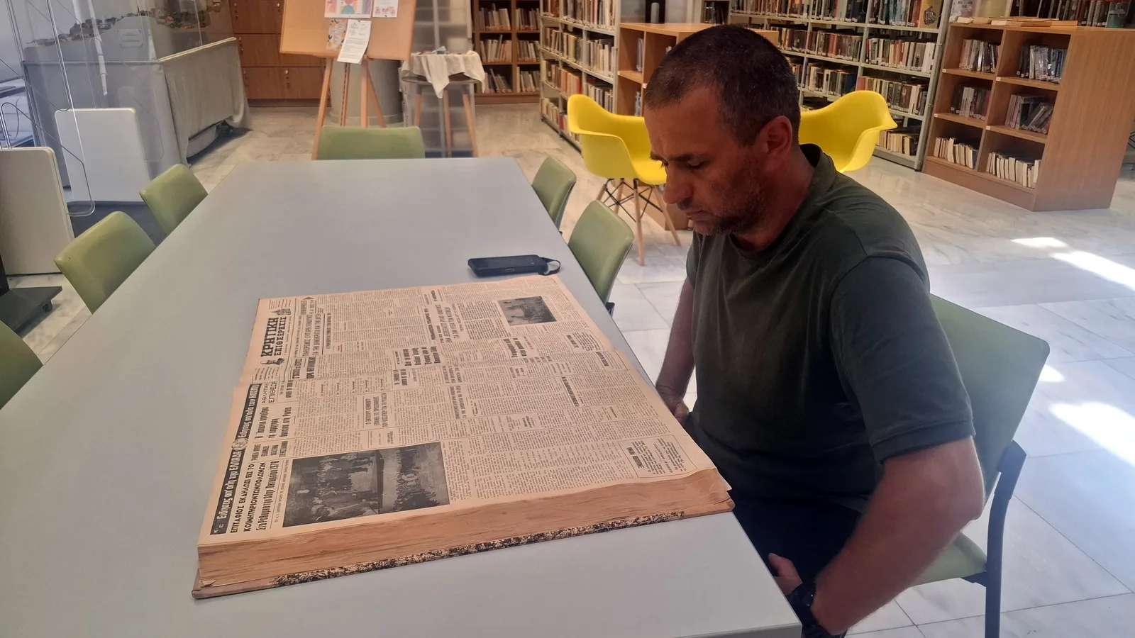 Tomasz Brzozowski przeglądający strony archiwalnych artykułów