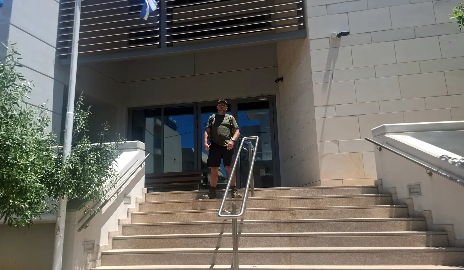 Tomasz Brzozowski przed wejściem do biblioteki w Rethymno